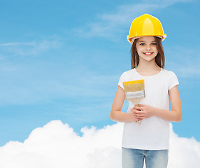 Image showing smiling little girl in helmet with paint brush