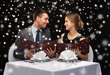 Image showing smiling couple with menus at restaurant