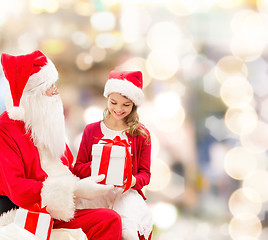 Image showing smiling little girl with santa claus and gifts