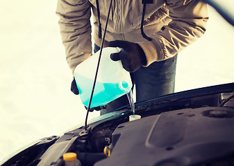 Image showing closeup of man pouring antifreeze into water tank