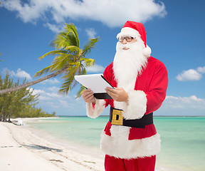 Image showing man in costume of santa claus with notepad