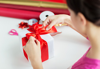 Image showing close up of woman decorating christmas presents