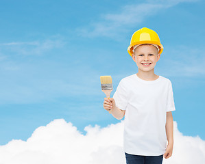 Image showing smiling little boy in helmet with paint brush