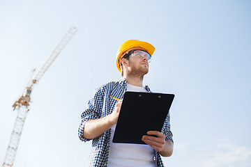 Image showing builder in hardhat with clipboard outdoors