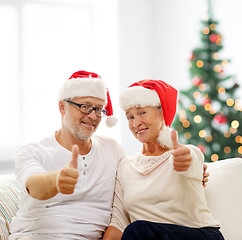 Image showing happy senior couple in santa helper hats