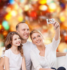 Image showing happy family with camera at home