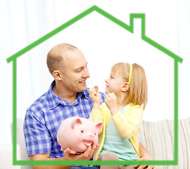 Image showing happy father and daughter with big piggy bank