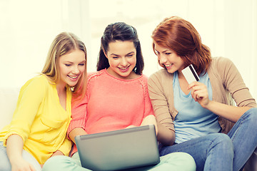 Image showing smiling teenage girls with laptop and credit card