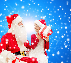 Image showing smiling little girl with santa claus and gifts