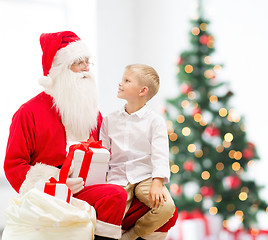 Image showing smiling little boy with santa claus and gifts