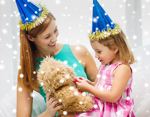 Image showing mother and daughter in party hats with toy