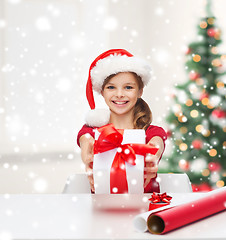 Image showing smiling girl in santa helper hat with gift box