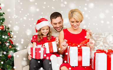 Image showing smiling family holding many gift boxes