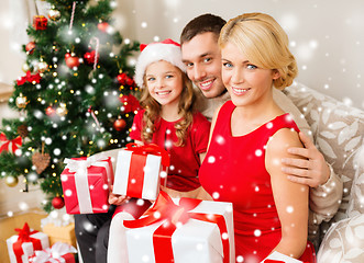 Image showing smiling family holding many gift boxes