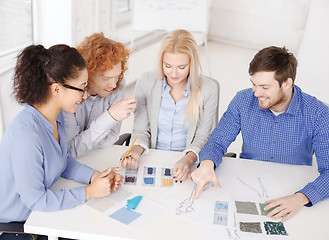 Image showing smiling creative team looking at sketch