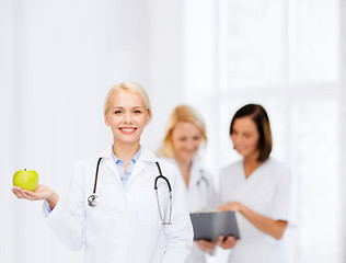 Image showing smiling female doctor with green apple