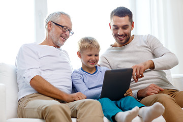 Image showing smiling family with tablet pc at home