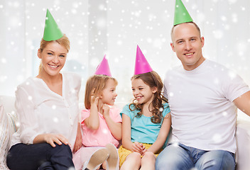 Image showing happy family with two kids in party hats at home