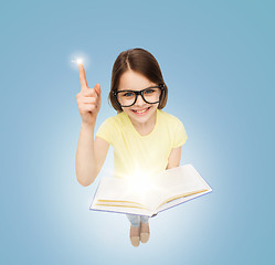 Image showing smiling little girl in eyeglasses with book