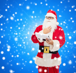 Image showing man in costume of santa claus with notepad