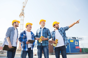 Image showing group of smiling builders with tablet pc outdoors