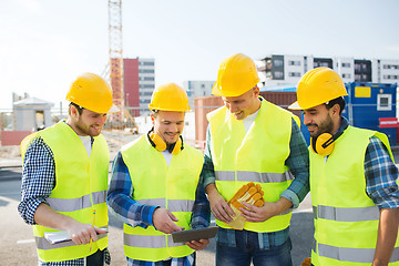 Image showing group of smiling builders with tablet pc outdoors