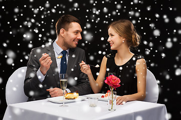 Image showing smiling couple eating dessert at restaurant