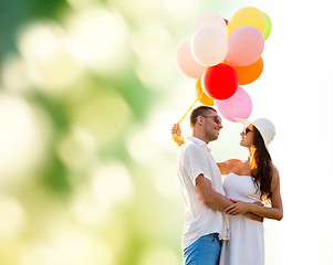 Image showing smiling couple with air balloons outdoors