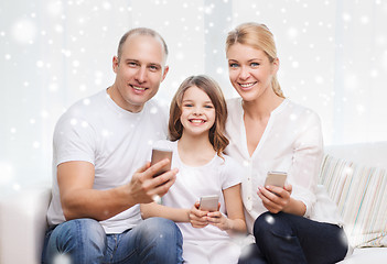 Image showing happy family with smartphones at home