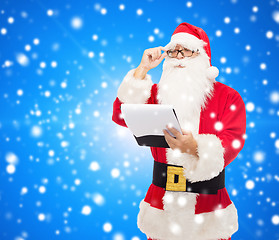 Image showing man in costume of santa claus with notepad