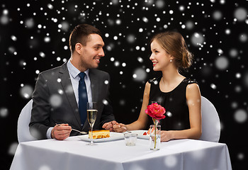 Image showing smiling couple eating dessert at restaurant