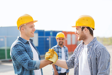 Image showing group of smiling builders in hardhats outdoors