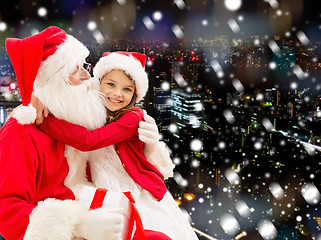 Image showing smiling little girl with santa claus and gifts