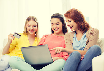 Image showing smiling teenage girls with laptop and credit card