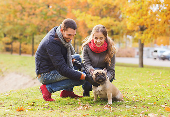 Image showing smiling couple with dog in autumn park