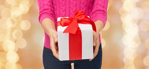 Image showing close up of woman in pink sweater holding gift box