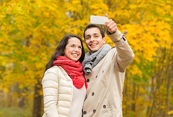 Image showing smiling couple hugging in autumn park