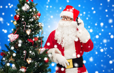 Image showing santa claus with smartphone and christmas tree