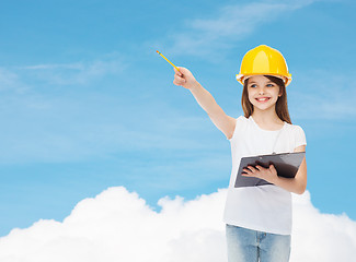 Image showing smiling little girl in hardhat with clipboard