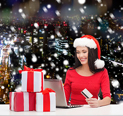 Image showing smiling woman with gifts, laptop and credit card