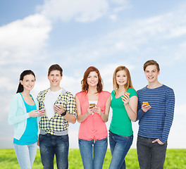 Image showing smiling students with smartphones