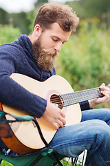 Image showing man with beard playing guitar in camping