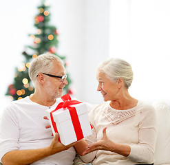 Image showing happy senior couple with gift box at home