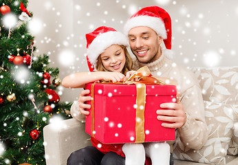 Image showing smiling father and daughter with gift box at home