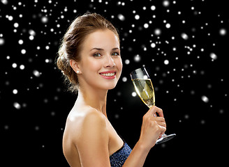 Image showing smiling woman holding glass of sparkling wine