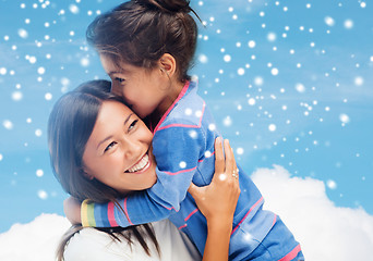 Image showing smiling little girl and mother hugging indoors