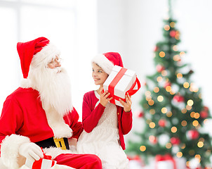 Image showing smiling little girl with santa claus and gifts