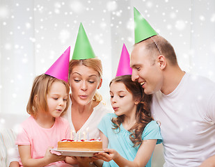 Image showing happy family with two kids in party hats at home