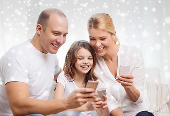 Image showing happy family with smartphones at home