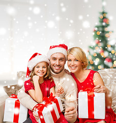 Image showing smiling family holding many gift boxes